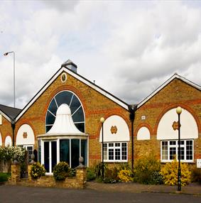 Main entrance to Rivehall Hotel, yellow brick building and white window panes.